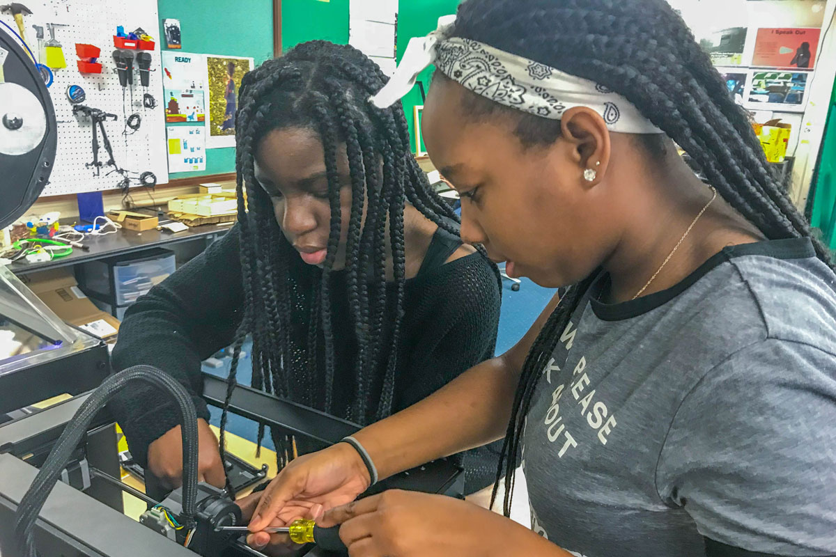 Two 7th grande girls take apart out a piece of filament that is stuck. Allowing students to troubleshoot issues that arise with equipment gives them confidence in problem solving and lets them take ownership of classroom machines.