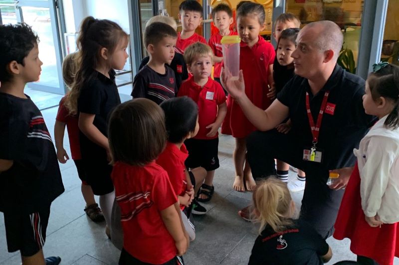 Kevin O'Shea shows Pre-Kindergarten students a praying mantis found on campus. Making real-life connections to insects and showing students that they are to be celebrated and not feared is important.